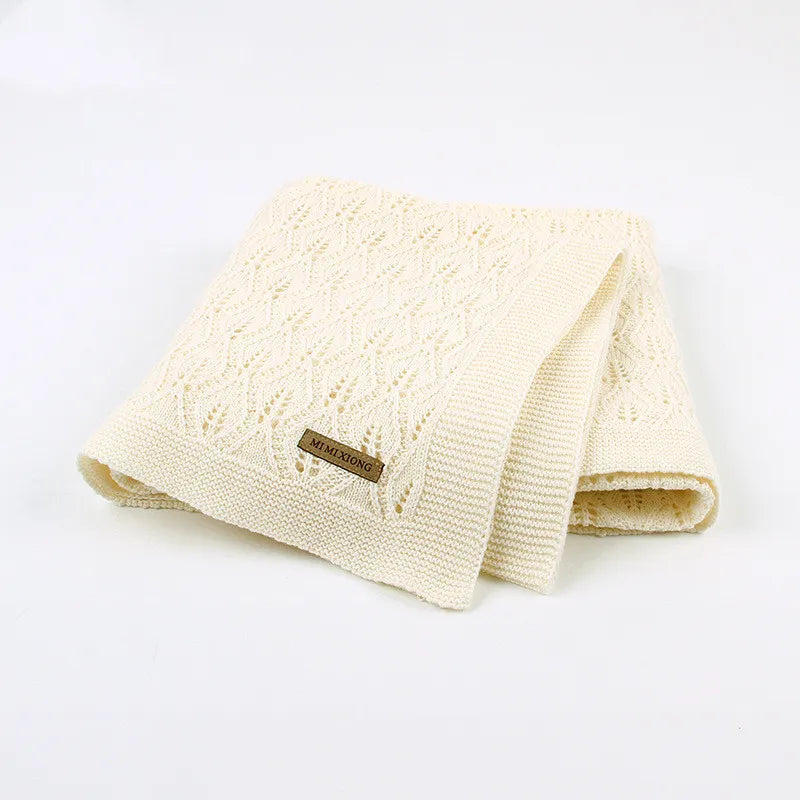 Couverture bébé en coton tricoté beige pliée
