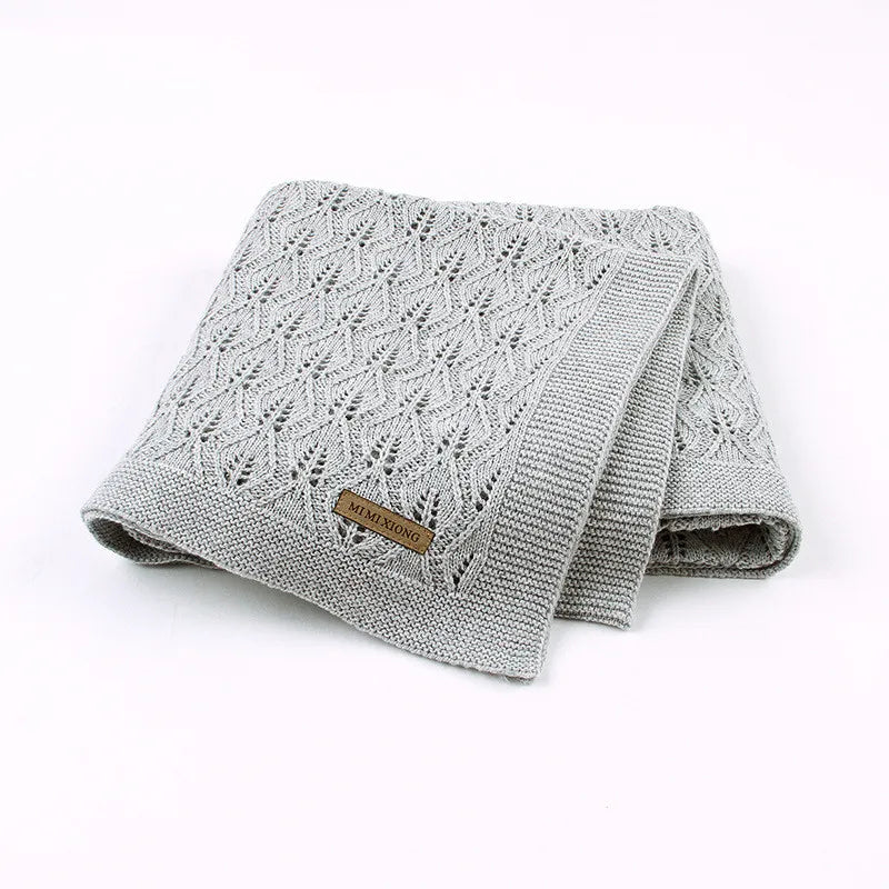 Couverture bébé en coton tricoté grise pliée