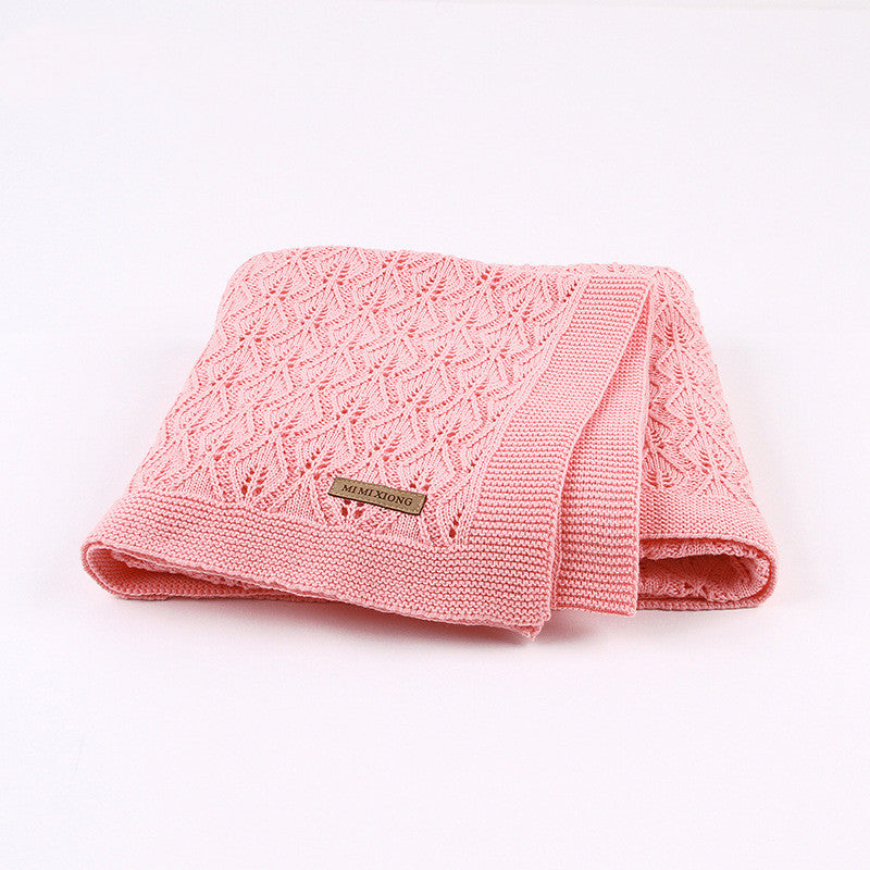 Couverture bébé en coton tricoté rose pliée